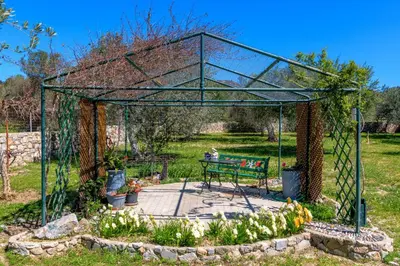 a garden with a bench in the middle at Billys House in Lardos
