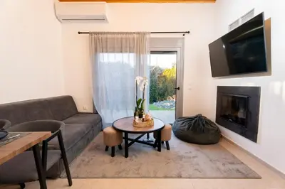 a living room with a couch and a table at Hera Elysium Retreat Villas in Kalavárda