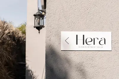 a sign on the side of a building with a lamp at Hera Elysium Retreat Villas in Kalavárda