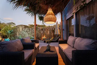 a patio with wicker furniture and a chandelier at Hera Elysium Retreat Villas in Kalavárda