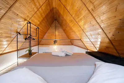a large bed in a room with a wooden ceiling at Hera Elysium Retreat Villas in Kalavárda