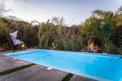 a blue swimming pool in a yard with plants at Hera Elysium Retreat Villas in Kalavárda