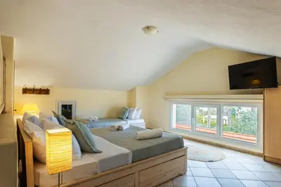 a bedroom with a large bed with a tv on the wall at Mi Casa South Rhodes in Lachania