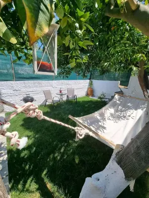 a rope with a table and chairs in a yard at The Garden House in Paradisi in Paradeísion