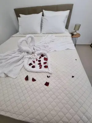 a white bed with a towel and hearts on it at The Garden House in Paradisi in Paradeísion
