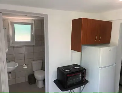 a small bathroom with a refrigerator and a toilet at The Garden House in Paradisi in Paradeísion