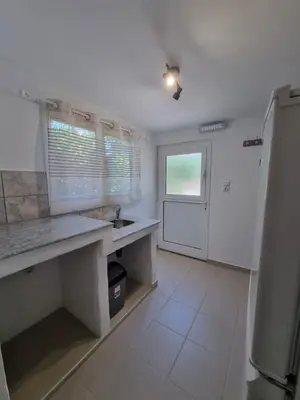 a white kitchen with a sink and a window at The Garden House in Paradisi in Paradeísion