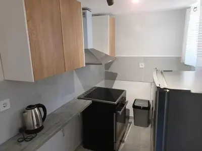 a kitchen with a black refrigerator and a trash can at The Sun House in Paradisi in Rhodes Town