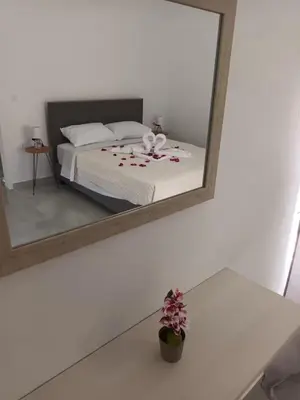 a mirror reflecting a bedroom with a bed and a flower pot at The Sun House in Paradisi in Rhodes Town
