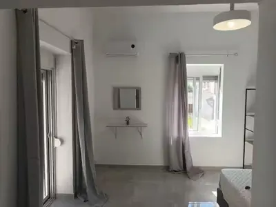 a white room with curtains and a bed and a window at The Sun House in Paradisi in Rhodes Town