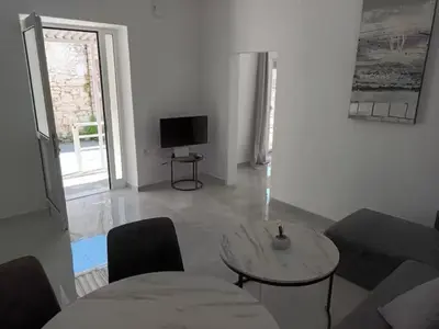 a living room with a couch and a table and a television at The Sun House in Paradisi in Rhodes Town