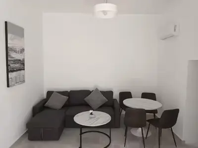 a living room with a black couch and two tables at The Sun House in Paradisi in Rhodes Town