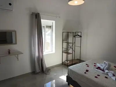 a bedroom with a bed and a window and a television at The Sun House in Paradisi in Rhodes Town