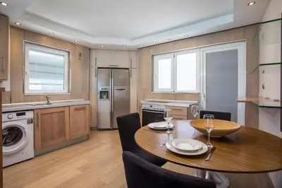 a kitchen with a wooden table and chairs and a dining room at Molos Seaside Apartment in Rhodes Town