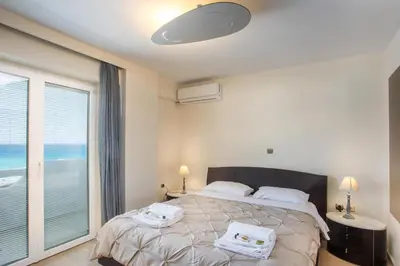 a bedroom with a bed and a large window at Molos Seaside Apartment in Rhodes Town