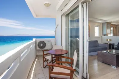 a room with a balcony with a view of the ocean at Molos Seaside Apartment in Rhodes Town