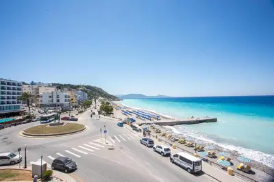 a city with cars parked on a road next to the beach at Molos Seaside Apartment in Rhodes Town