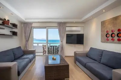 a living room with a couch and a tv at Molos Seaside Apartment in Rhodes Town