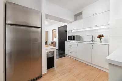 a stainless steel refrigerator in a kitchen with white cabinets at Elli City Apartment in Rhodes Town