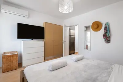 a bedroom with a large bed with a flat screen tv at Elli City Apartment in Rhodes Town