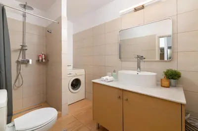 a bathroom with a sink and a washing machine at Elli City Apartment in Rhodes Town