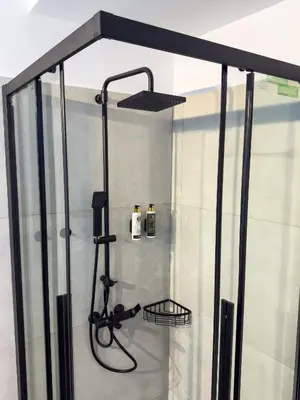 a shower with a glass door and a shower head at La casa di pantelis with Luxury Pool in Archangelos