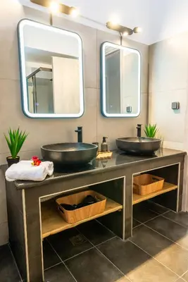 two sinks in a bathroom with two mirrors at La casa di pantelis with Luxury Pool in Archangelos