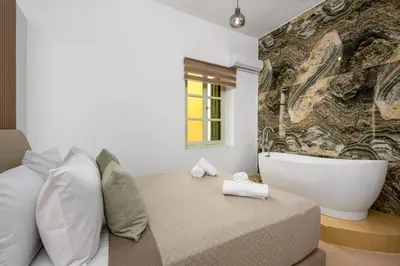 a bedroom with a bath tub and a bed at Agkyra Studio in Symi