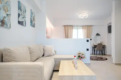 a white living room with a couch and a table at The Azure Suites in Haraki