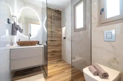 a bathroom with a shower and a toilet and a sink at The Azure Suites in Haraki