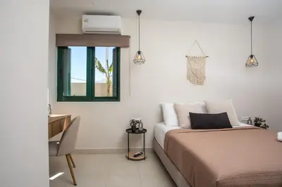 a bedroom with a bed and a desk and a window at Lythari Summer Villa in Afantou