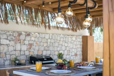 a table with plates of food and lights at Lythari Summer Villa in Afantou