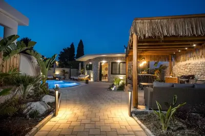 a backyard with a swimming pool and a house at Lythari Summer Villa in Afantou