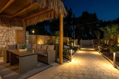 a patio with a couch and a table with lights at Lythari Summer Villa in Afantou