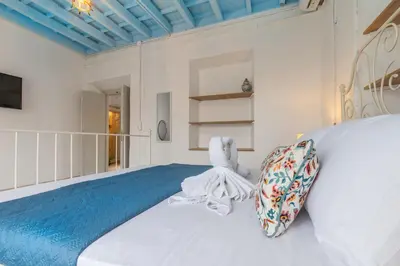 a bedroom with a white bed with a teddy bear on it at Xenofon Traditional Rooms in Rhodes Town