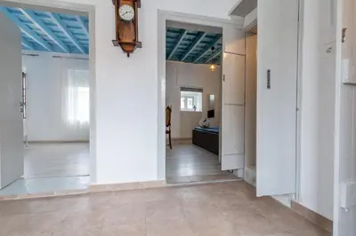 a hallway with white walls and a clock on the wall at Xenofon Traditional Rooms in Rhodes Town