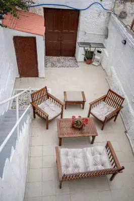 a patio with three benches and a table and a door at Xenofon Traditional Rooms in Rhodes Town