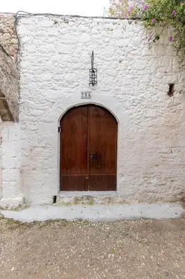 a large wooden door in a white brick wall at Xenofon Traditional Rooms in Rhodes Town