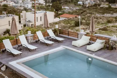 a pool on a deck with chairs and tables at Villa Afandou Bliss with private pool & panoramic sea view in Afantou