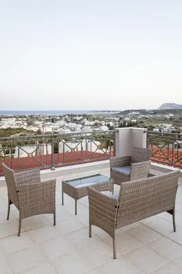 a patio with chairs and a table on a balcony at Villa Afandou Bliss with private pool & panoramic sea view in Afantou