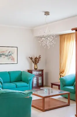 a living room with blue couches and a coffee table at Villa Afandou Bliss with private pool & panoramic sea view in Afantou