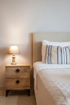 a bedroom with a bed and a nightstand with a lamp at Villa Afandou Bliss with private pool & panoramic sea view in Afantou