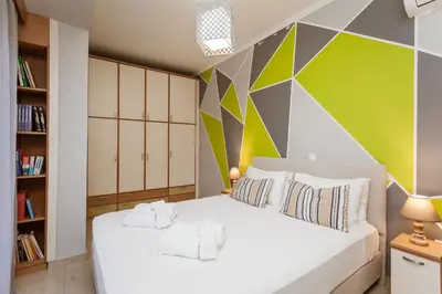 a bedroom with a white bed with a colorful wall at Villa Afandou Bliss with private pool & panoramic sea view in Afantou