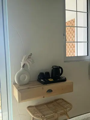 a table with a vase on a shelf in a room at Delfini Pearl Stegna Beach in Archangelos