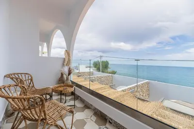 a balcony with chairs and a view of the ocean at Delfini Pearl Stegna Beach in Archangelos