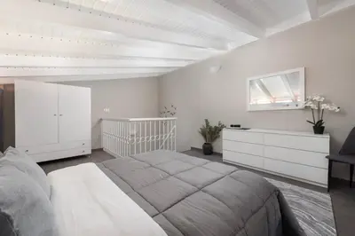 a white bedroom with a large bed and a crib at Golden sand 4 in Ialyssos