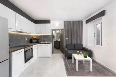a kitchen and living room with a couch and a table at Golden sand 4 in Ialyssos