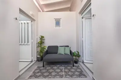 a living room with a chair in a hallway at Golden sand 4 in Ialyssos
