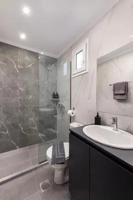 a bathroom with a sink and a toilet and a shower at Golden sand 5 in Ialyssos