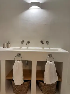 a bathroom sink with two towels hanging from it at Aetheria Traditional House 2 in Koskinou